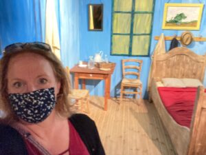 M.J. Pullen in facemask in front of Van Gogh immersive art exhibit